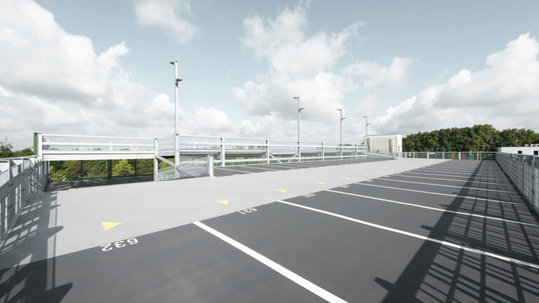 Oberstes Parkdeck mit markierten Stellplätzen, Geländern und Lichtmasten unter hellem Himmel.