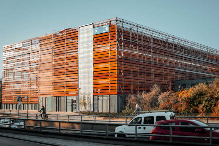 Ansicht des P+R-Parkhauses Gouda mit orangefarbener Lamellenfassade im städtischen Umfeld.
