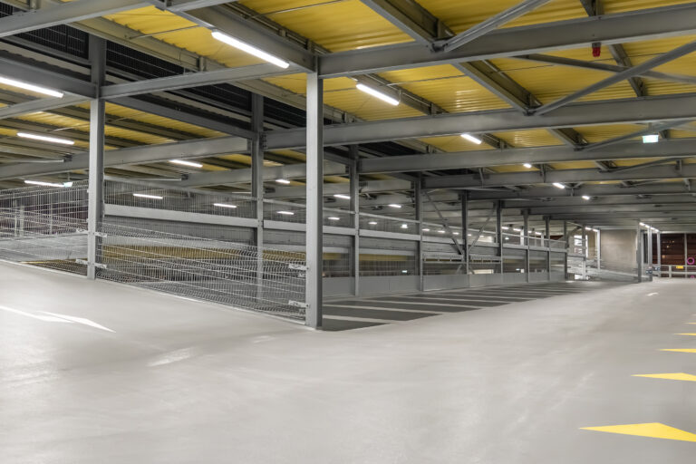 Innenansicht eines Parkdecks mit Stahltragwerk, Fahrgasse und Rampe.
